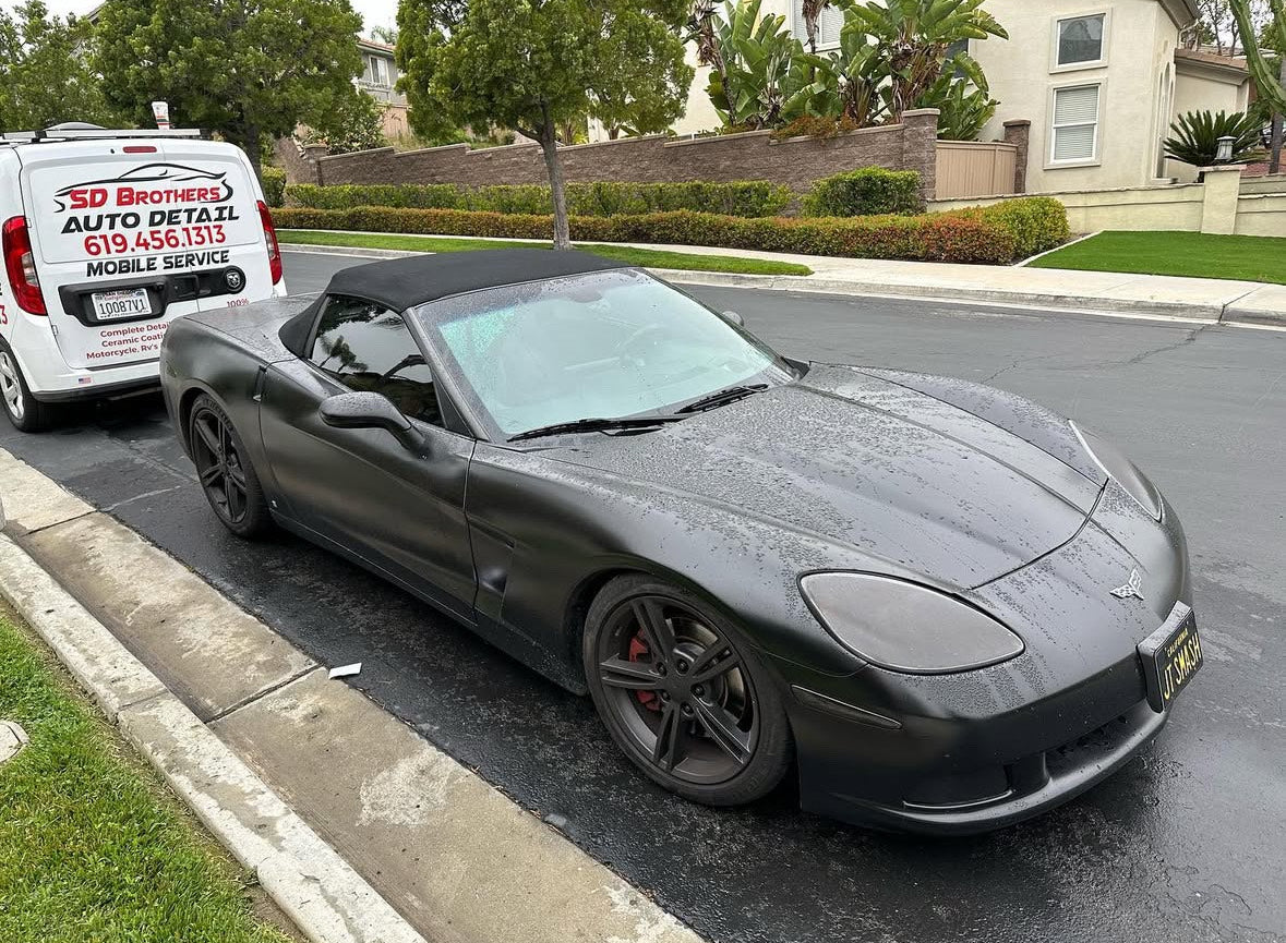 Gray convertible sports car parked on a residential street.