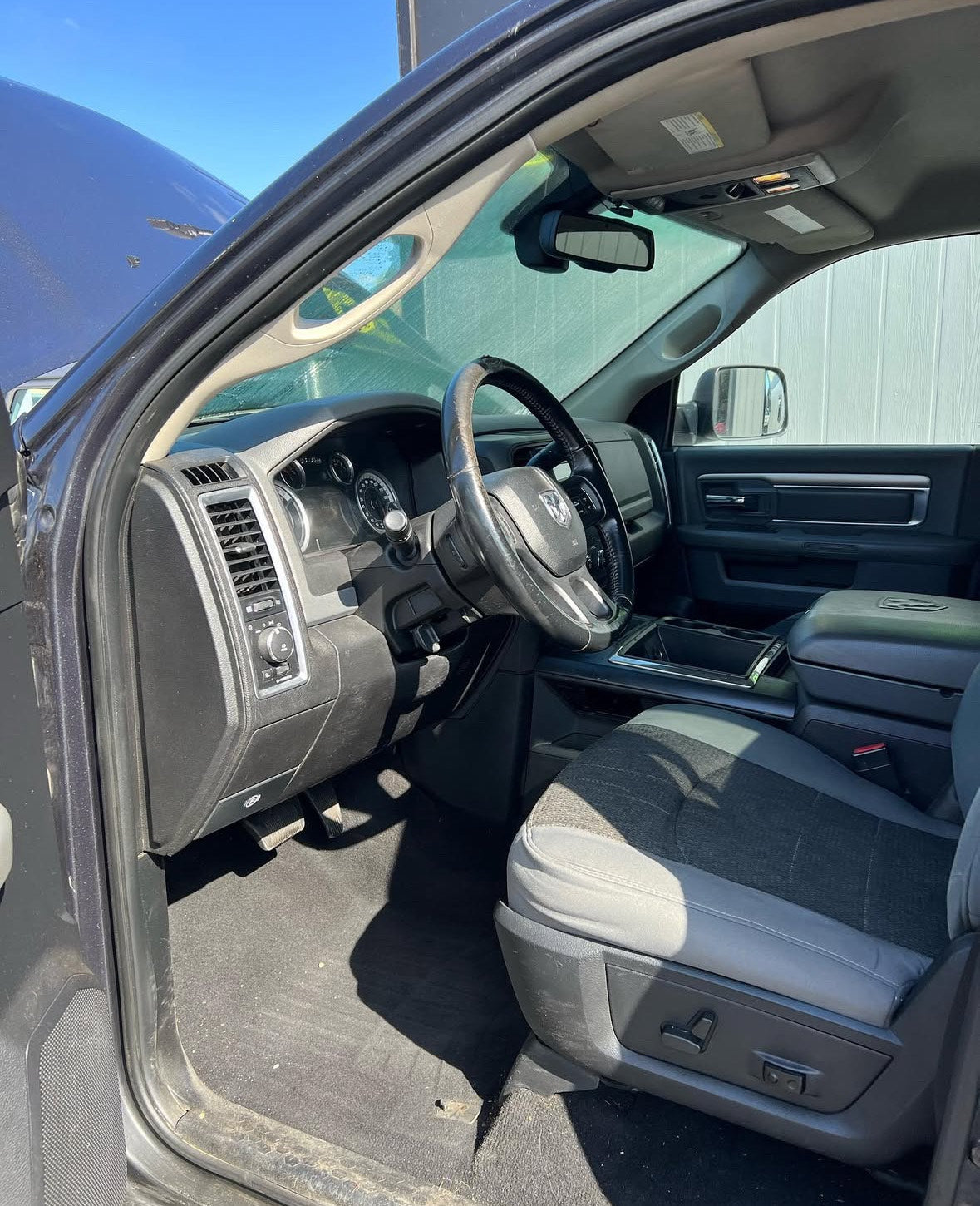 Interior of a vehicle with steering wheel and dashboard visible.